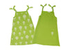 A green dress with a white floral design on one side and a small pocket with a white flower on the other side.