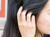 A close-up of the adjustable brass ring on a girl’s index finger.