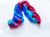 A crumpled silk scarf in vivid blue, pink, and purple colors.